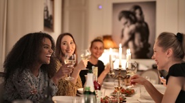 A photo of beautiful foreign women having wine and socializing while seated at a fancy dinner table